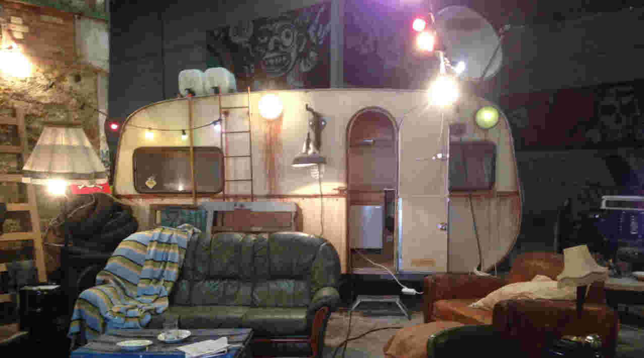 décor de squat avec caravane et fauteuil dans une usine désaffectée pour la série télévisée José