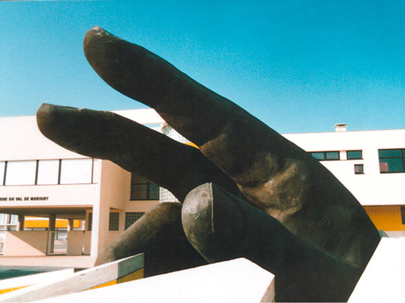 sculpture en faux granit d'une main géante installée sur un lieu public..