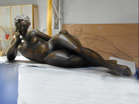 sculpture en atelier d'une femme allongée en polystyrène peint.